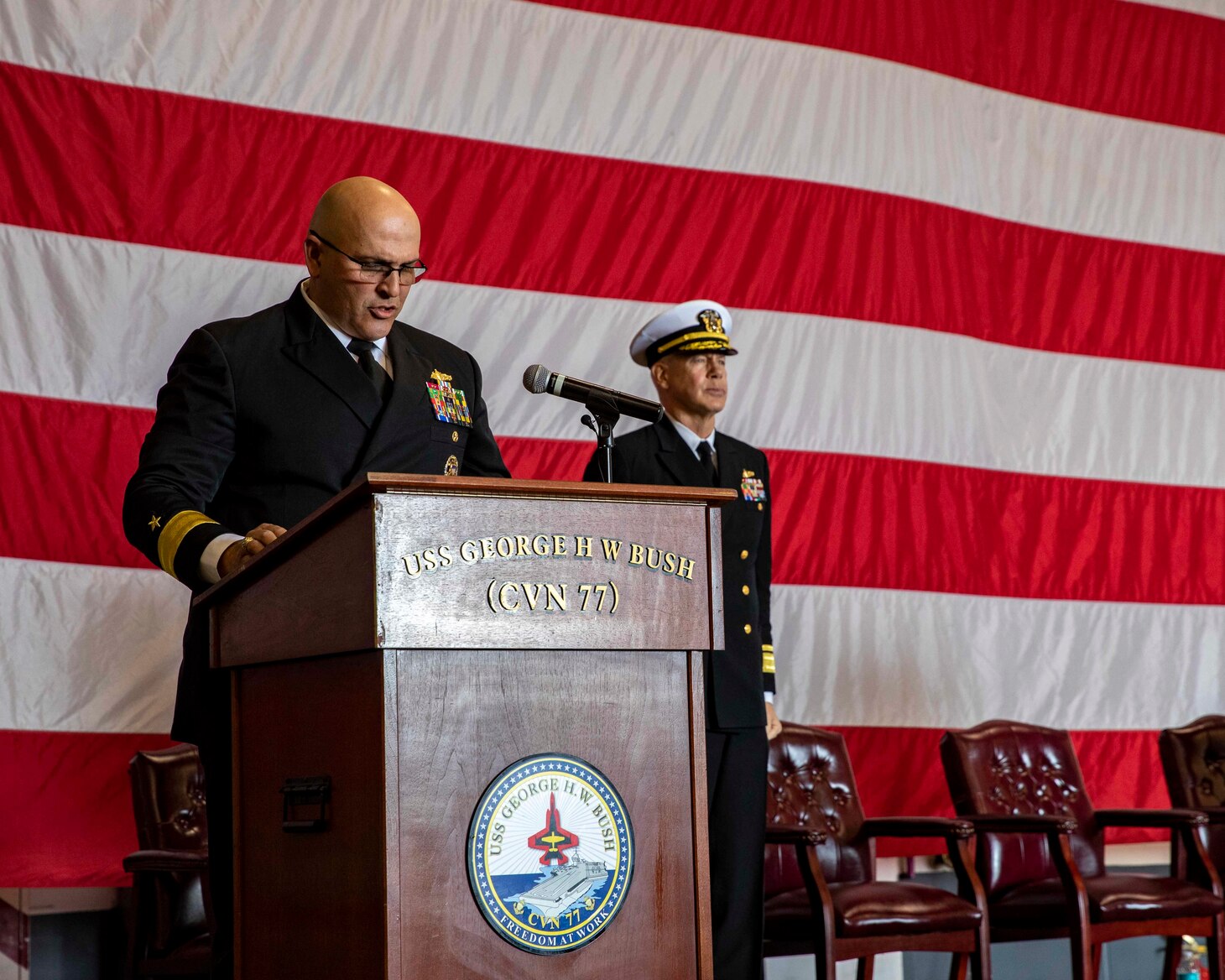 NORFOLK, Va. (April 6, 2022) Rear Adm. Dennis Velez delivers remarks during a change of command ceremony aboard the aircraft carrier USS George H.W. Bush (CVN 77) April 6, 2022. During the ceremony, Velez relieved Rear Adm. Rick Cheeseman, as Commander, Carrier Strike Group (CSG) 10. CSG-10 is an integrated combat weapons system that delivers superior combat capability to deter, and if necessary, defeat America’s adversaries in support of national security. It achieves its mission by projecting the combined power of George H.W. Bush, Carrier Air Wing 7, Destroyer Squadron 26, and the Ticonderoga-class guided-missile cruiser USS Leyte Gulf (CG 55).  (U.S. Navy photo by Mass Communication Specialist 3rd Class Noah Eidson)