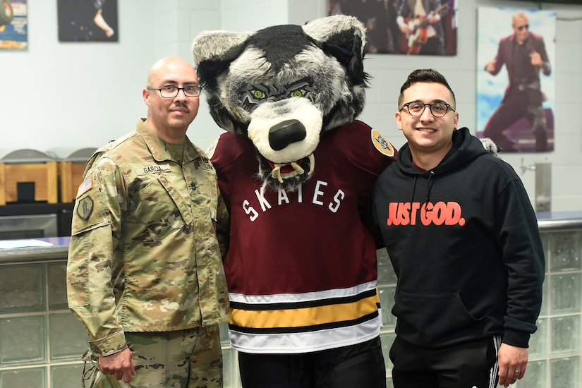Sgt. 1st Class Moises Garcia, left, and 1st. Lt. Marcus Guerra, right, Chaplain Candidate, both assigned to the 85th U.S. Army Reserve Support Command pause for a photo with the Chicago Wolves mascot Skates the Gray Wolf during a Chicago Wolves military appreciation game, May 21, 2022, at the All-State Arena.