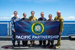 Royal Navy and Australian Defence Force personnel pose for a photo on the flight deck aboard Military Sealift Command hospital ship USNS Mercy (T-AH 19). Mercy is currently underway as part of Pacific Partnership 2022. Now in its 17th year, Pacific Partnership is the largest annual multinational humanitarian assistance and disaster relief preparedness mission conducted in the Indo-Pacific.