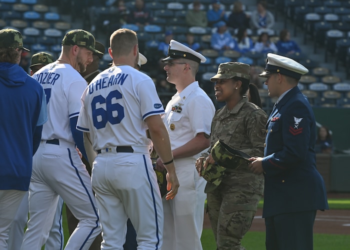 Members with the Kansas City Royals exchange hats with members of the armed forces.