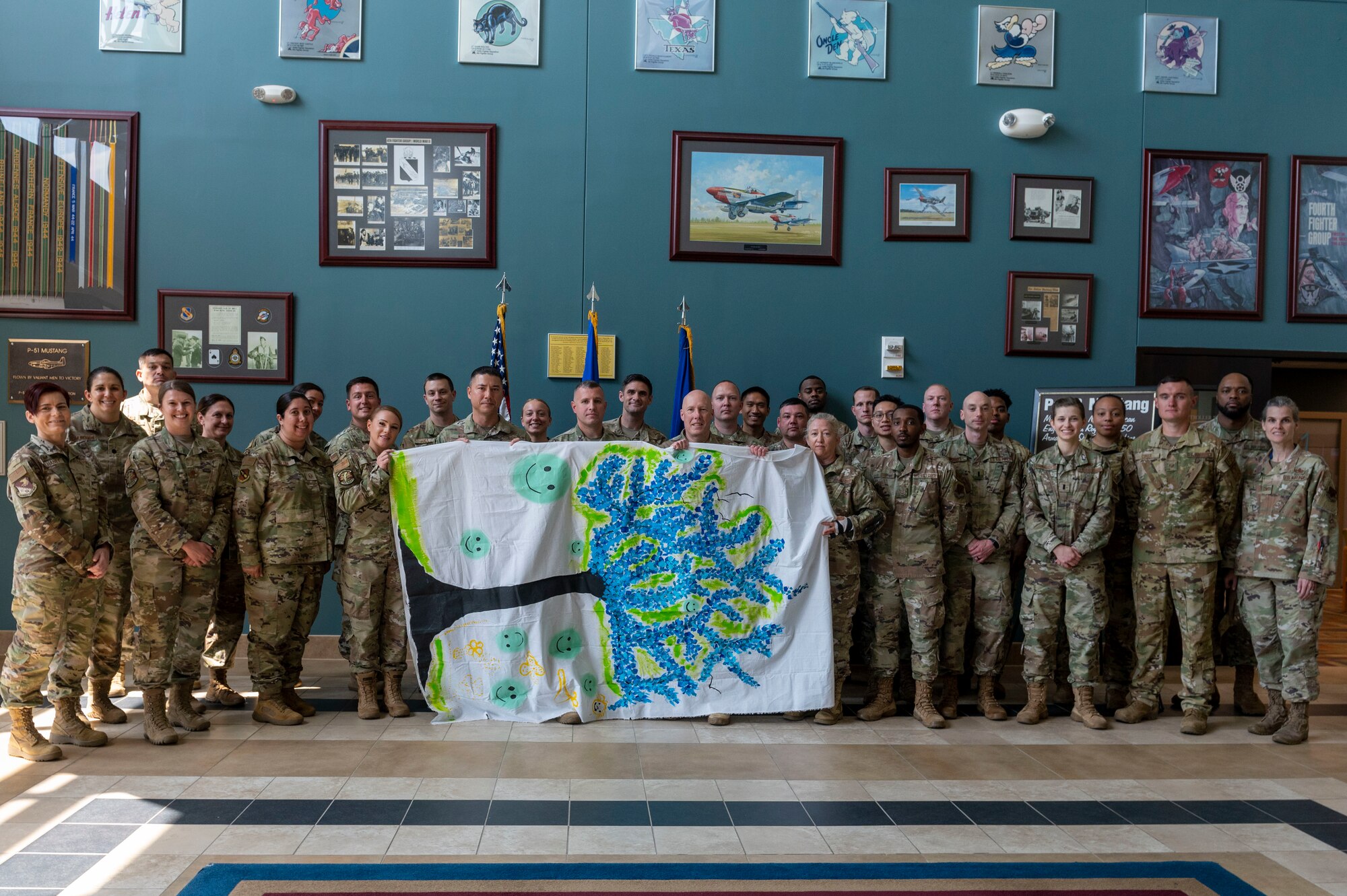 Brig. Gen. Daniel Gabrielli, Minnesota Air National Guard’s Assistant Adjutant General Guard and former commander for Task Force Holloman during Operation Allies Welcome, and Airmen assigned to the 4th Fighter Wing pose for a photo while holding up a painting at Seymour Johnson Air Force Base, North Carolina, May 20, 2022. From Aug. 31, 2021, to Jan. 26, 2022, Task Force Holloman provided temporary housing and support services for approximately 7,100 Afghan guests after the evacuation of Afghanistan took place in early August. (U.S. Air Force photo by Senior Airman Kevin Holloway)