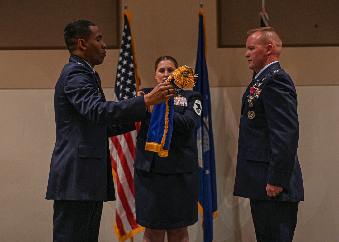 Col. Marcus Jackson, Space Base Delta 2 commander rolls up the 460th Mission Support Group guidon in front of Col. Brian Chellgren, the last 460th Mission Support Group commander, during an inactivation ceremony on Buckley Space Force Base, Colo., May 23, 2022.