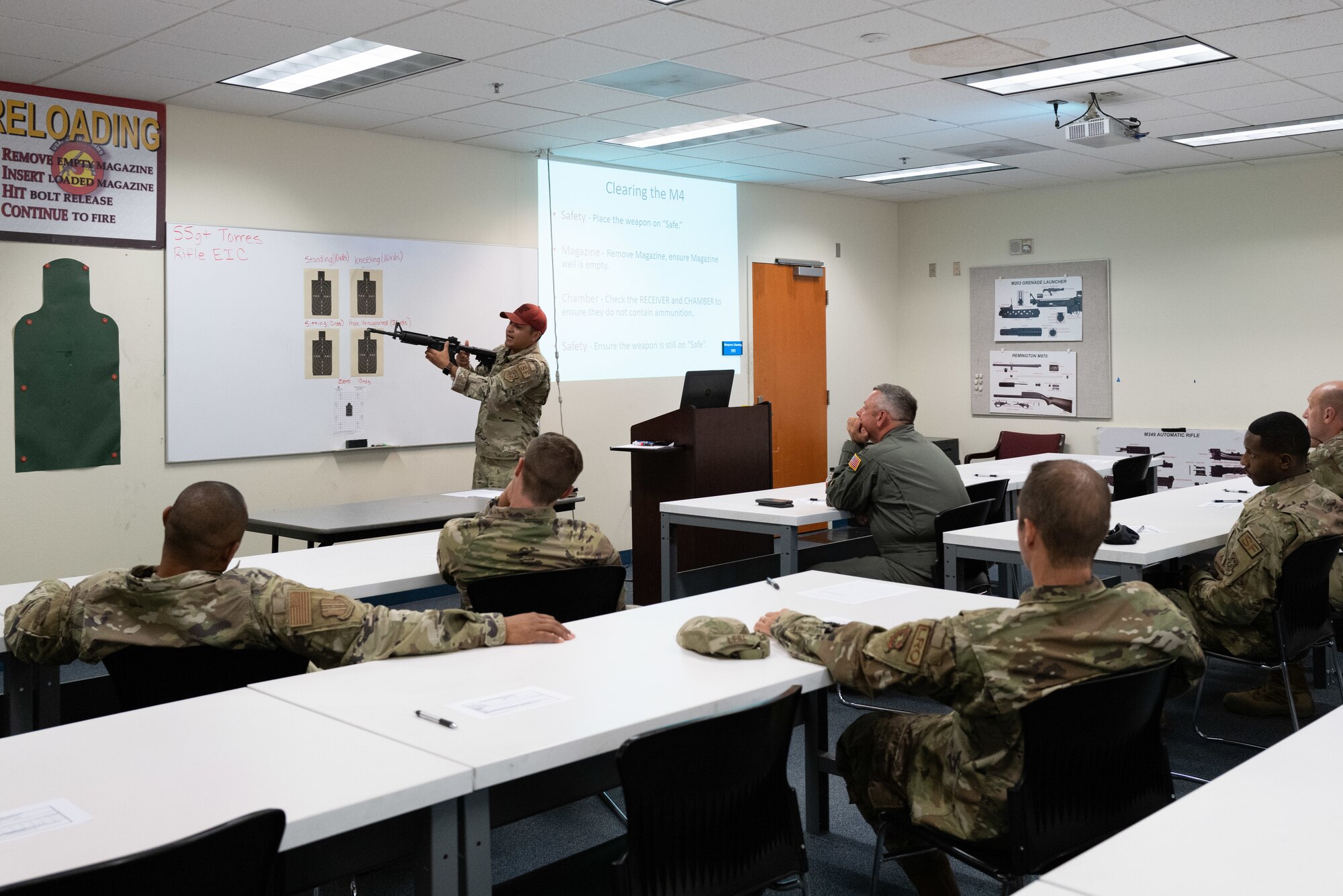 Airmen talks in front of other Airmen in a classroom.