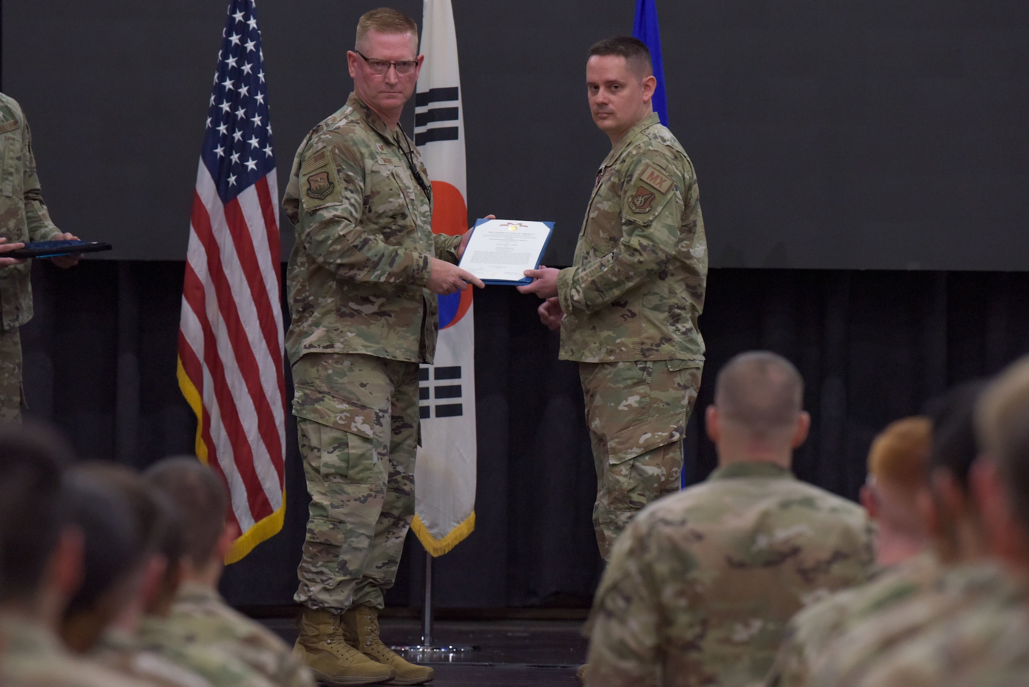 Col. Brian Moore, left, 51st Maintenance Group commander, presents a Meritorious Service Medal certificate to Maj. Benjamin Abshire, 51st Maintenance Squadron outgoing commander, during 51st MXS change of command ceremony at Osan Air Base, Republic of Korea, May 23, 2022.