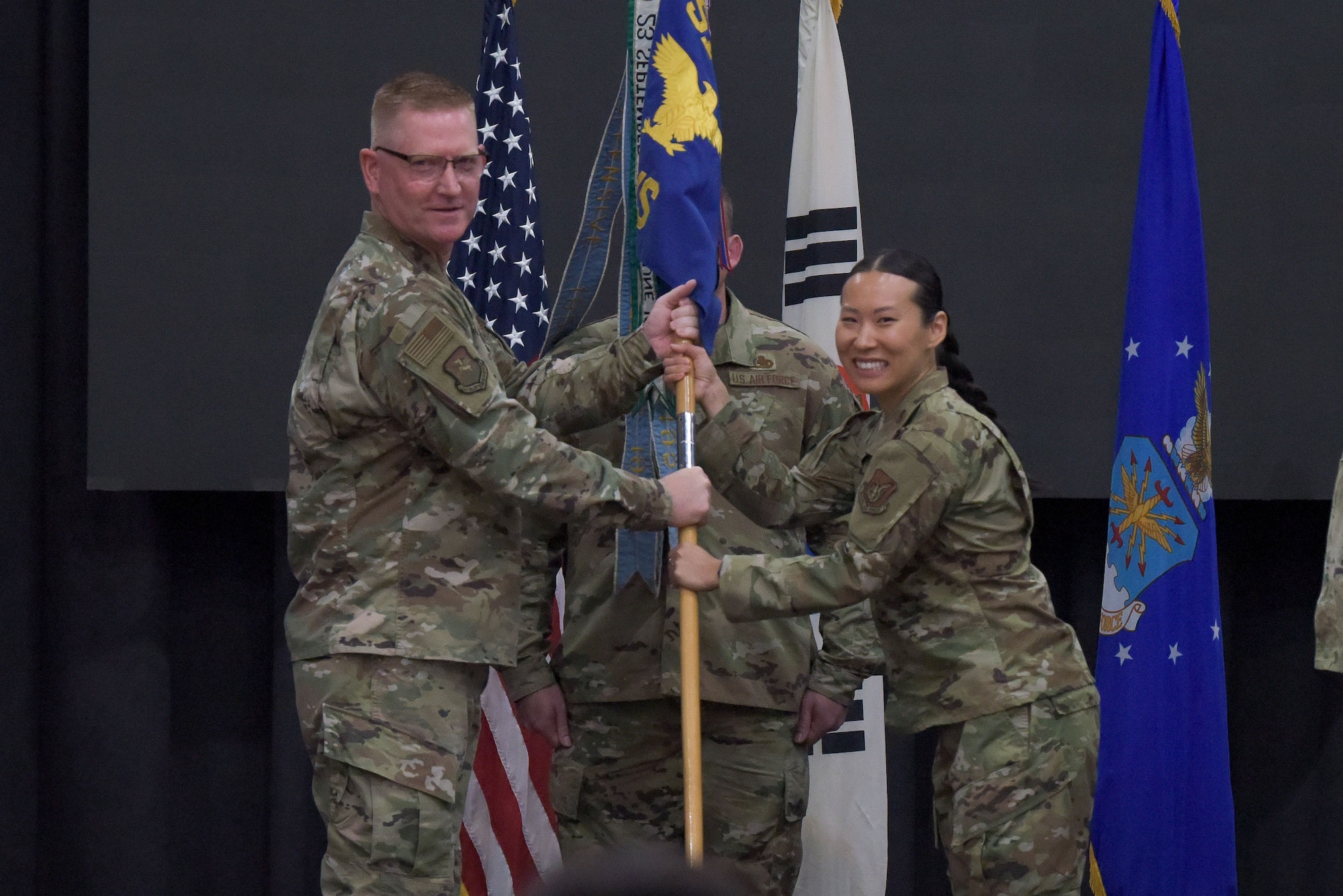 Col. Brian Moore, left, 51st Maintenance Group commander, presents Maj. Anna Jung, 51st Maintenance Squadron incoming commander, the 51st MXS guidon during the 51st MXS change of command ceremony at Osan Air Base, Republic of Korea, May 23, 2022.