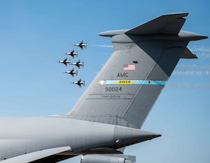 The U.S. Air Force Thunderbirds fly past the tail of a C-5M Super Galaxy during the 2022 Thunder Over Dover Airshow, May 22, 2022, at Dover Air Force Base, Delaware. The Thunderbirds performed precision flying maneuvers during the 2022 Thunder Over Dover Open House and Airshow May 21-22. (U.S. Air Force photo by Senior Airman Faith Schaefer)
