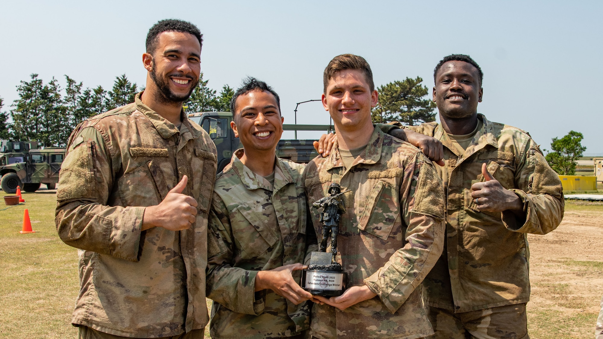 Staff Sgt. Trenton Collins, 8th Security Forces defender, left, Airman 1st Class Melchor Sevillano, 8 SFS defender, A1C Mark Orlowski, 8 SFS defender, Senior Airman Jehvon Moore, 8 SFS defender, right, showcase their trophy for winning the Defender challenge during Police Week 2022 at Kunsan Air Base, Republic of Korea, May 17, 2022. The Defender Challenge was designed to be a test of physical strength, memory, as well as individual and teamwork skills. (U.S. Air Force photo by Staff Sgt. Jesenia Landaverde)