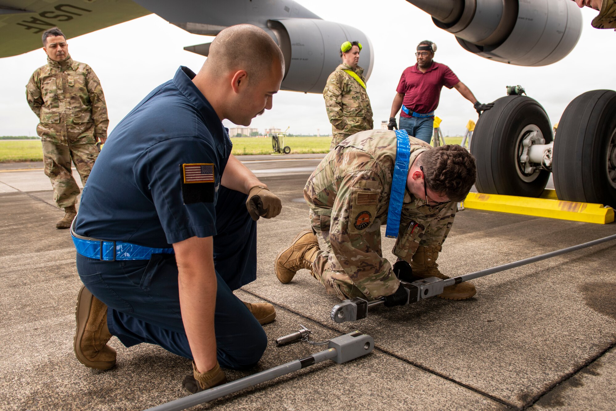 Tow airmen attach lengths of metal rods together