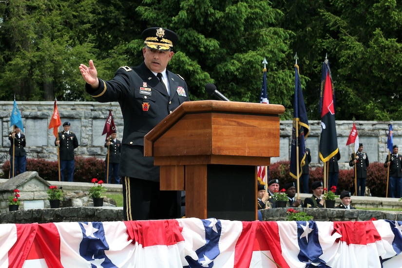Maj. Gen. Mark McCormack, 28th Infantry Division commander, notes the addition of a Battle of the Bulge monument to the division shrine during the unit's annual memorial service at Boalsburg, Pa. May 22, 2022. The 2022 memorial service marked the return of the colorful ceremony to the grounds along Spring Creek after the coronavirus pandemic canceled the event in 2020 and forced a scaled-down ceremony in 2021.