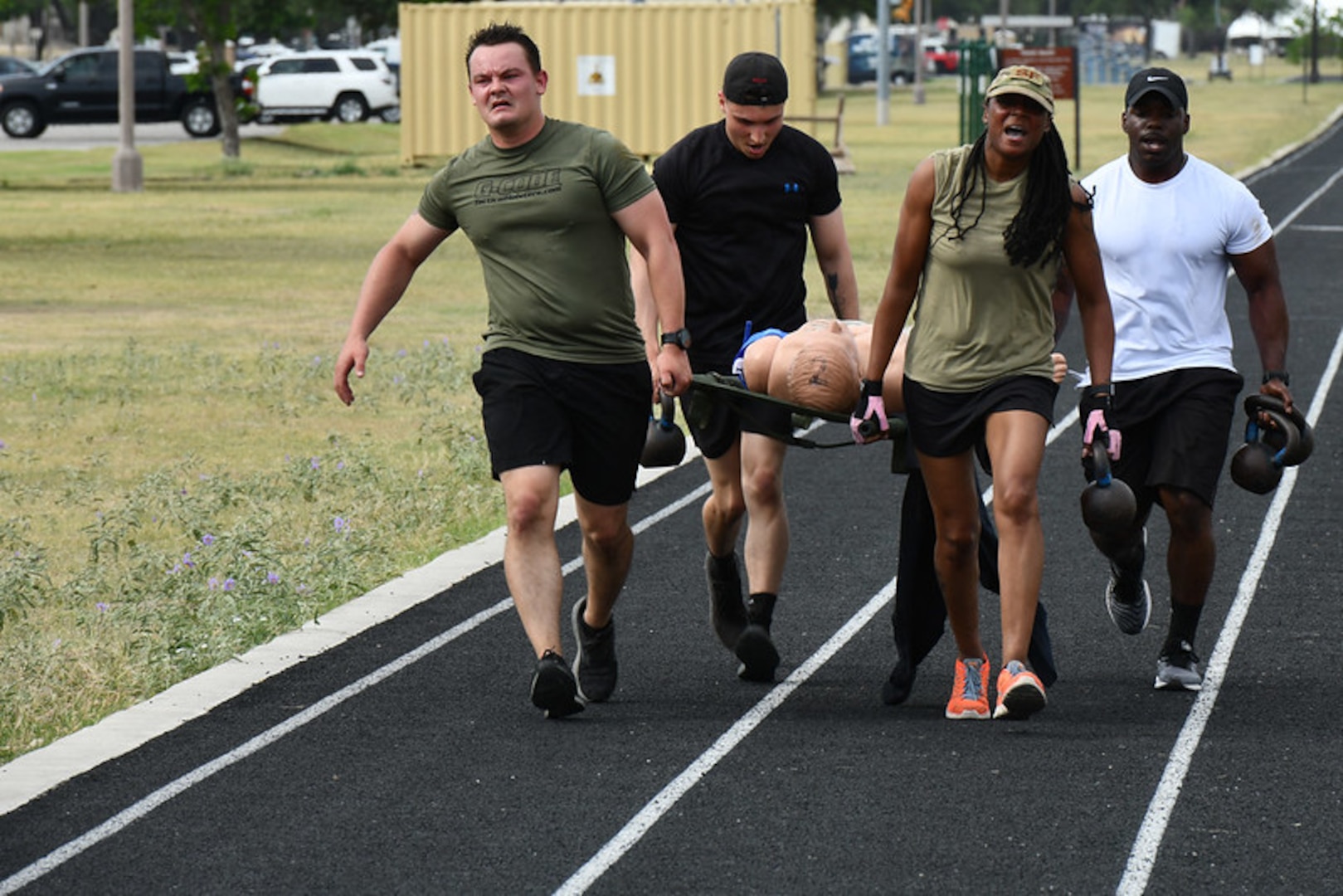 Three people carrying a litter