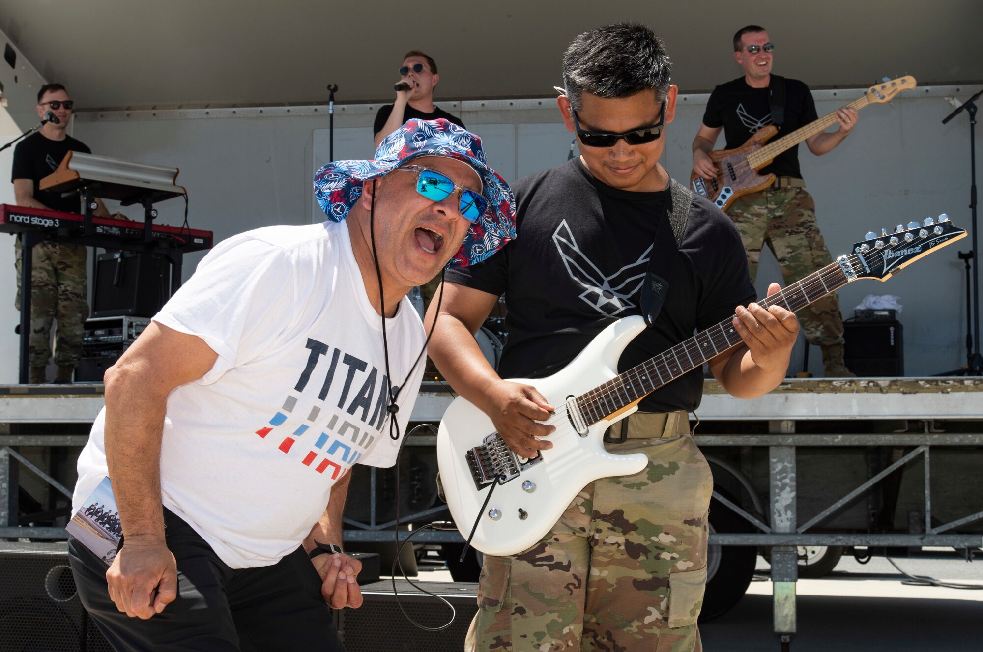 An airshow spectator joins Full Spectrum guitarist Tech. Sgt. Daniel Santos as he plays a solo during the 2022 Thunder Over Dover Airshow at Dover Air Force Base, Delaware, May 21, 2022. Full Spectrum is a part of the U.S. Air Force Heritage of America Band based out of Joint Base Langley-Eustis, Virginia. (U.S. Air Force photo by Roland Balik)