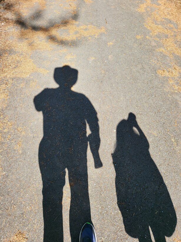 Photo of shadows of Jason Anderson and his daughter at the Woodard Bay Natural Resources Conservation Area, Olympia, Washington.