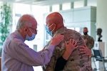 Command Sgt. Maj. Joshua Brown, senior enlisted adviser of the 76th Infantry Brigade Combat Team, hugs nurse Jackie Brames while Dr. Lawrence H. Einhorn embraces them. Brown was awarded the Legion of Merit at the Indiana University Health Cancer Pavilion May 12, 2022, and gave the medal to Einhorn as thanks for treating him for cancer 24 years earlier.
