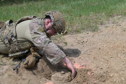 Staff Sgt. Brian Goergen, an explosives ordnance disposal technician from the 434th Air Refueling Wing, Grissom ARB, Ind., uncovers potential explosives during a training event May 18, 2022, at Fort McCoy, Wis. Airmen, Marines and Soldiers from a range of units and career fields participated in the Audacious Warrior exercise with participation.