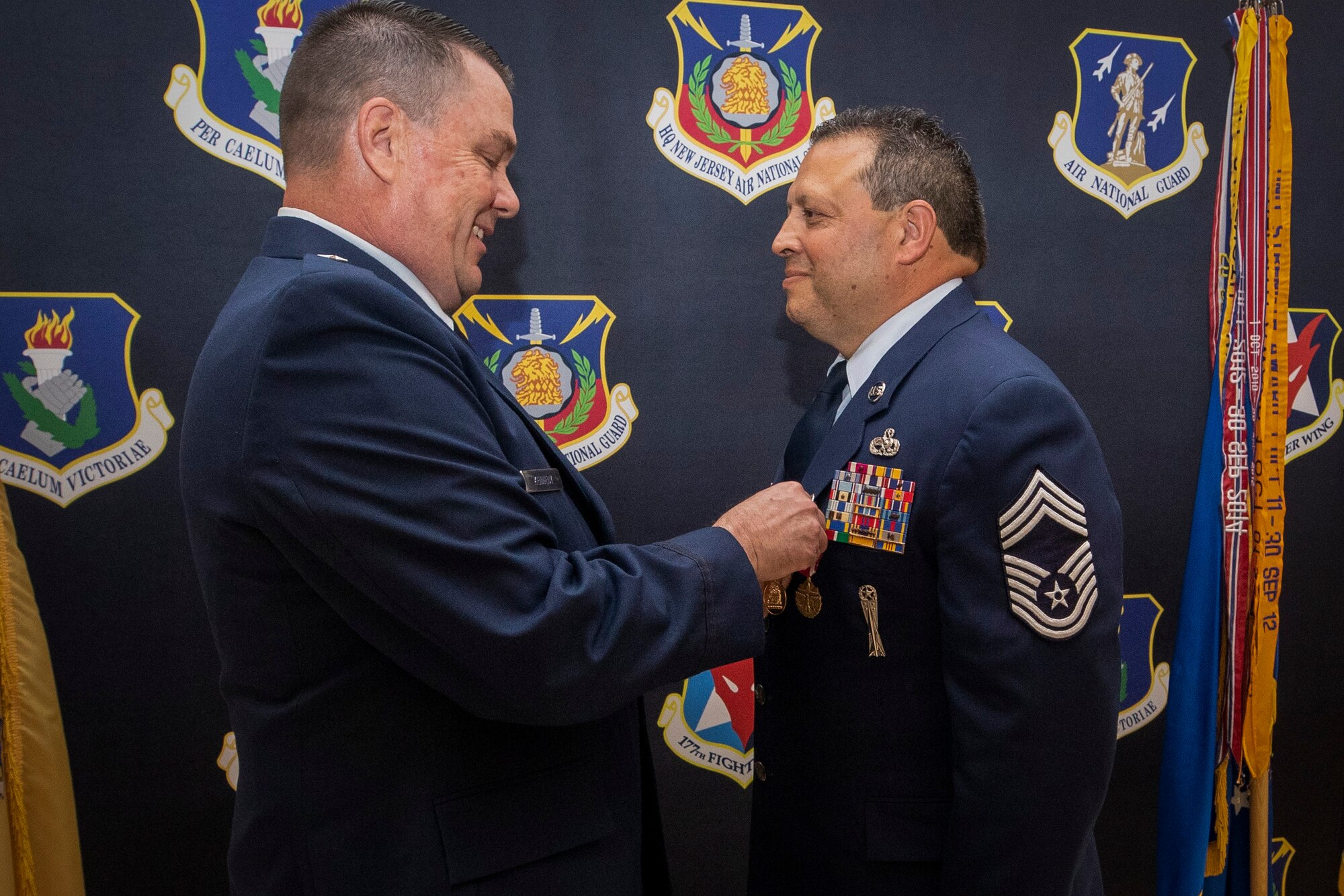 U.S. Air Force Brig. Gen. Patrick Kennedy, left, presents Chief Master Sgt. Raynaldo Morales with the meritorious service medal during a retirement ceremony on Joint Base McGuire-Dix-Lakehurst, New Jersey, May 22, 2022. Morales served the Air National Guard and Air Force for 35 years.