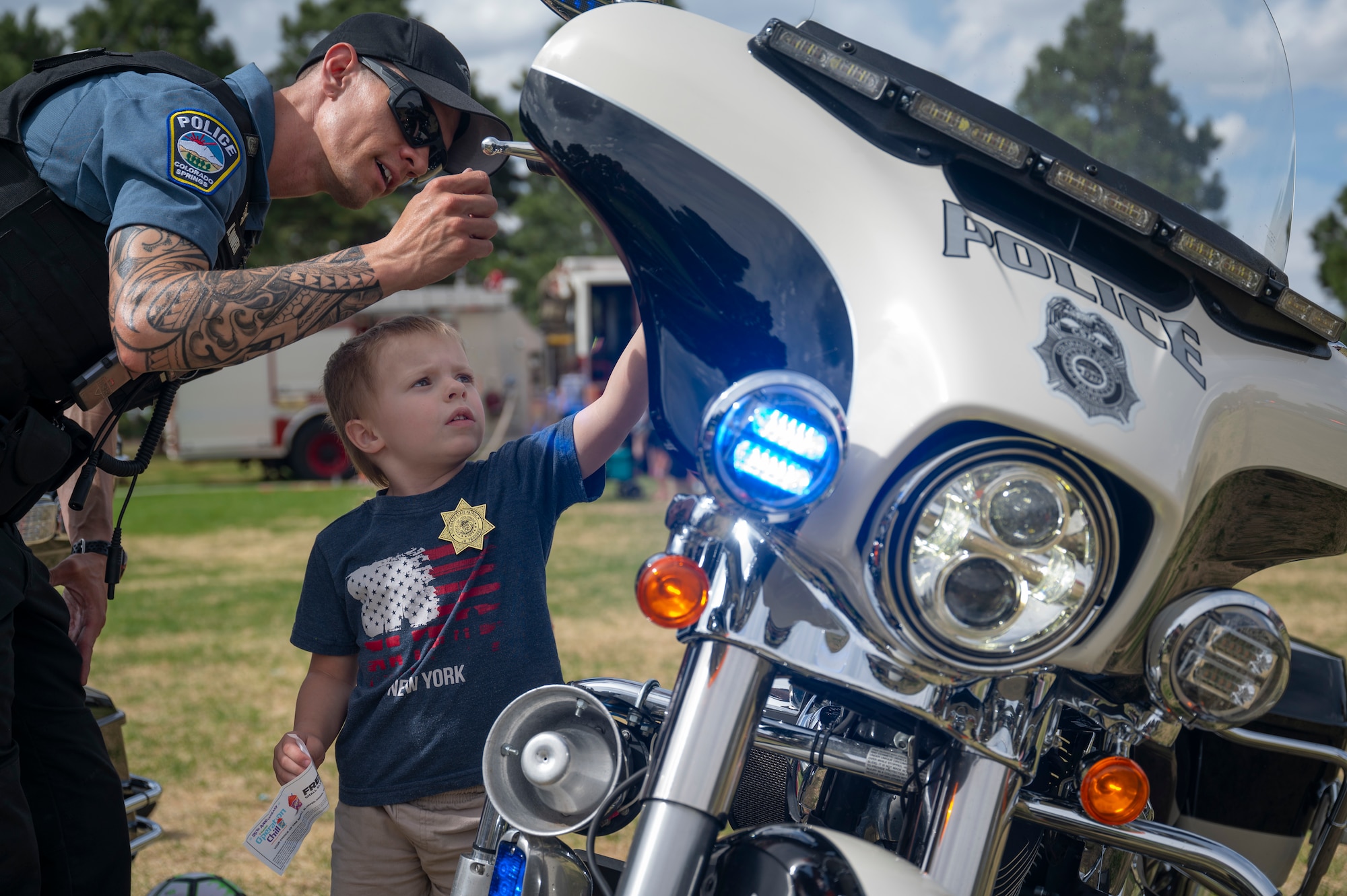 Kegan Mowery, Colorado Springs Police Department motor officer, shows Ryan, 4, a police motorcycle during the Defender’s Fair at Peterson Space Force Base, Colorado, May 19, 2022. All proceeds raised during the 21st SFS Police Week events went to the Pikes Peak Peace Officers Memorial Foundation, an organization that honors federal, state local and military law enforcement officers who died in the line of duty. (U.S. Space Force photo by Senior Airman Jonathan Whitely)