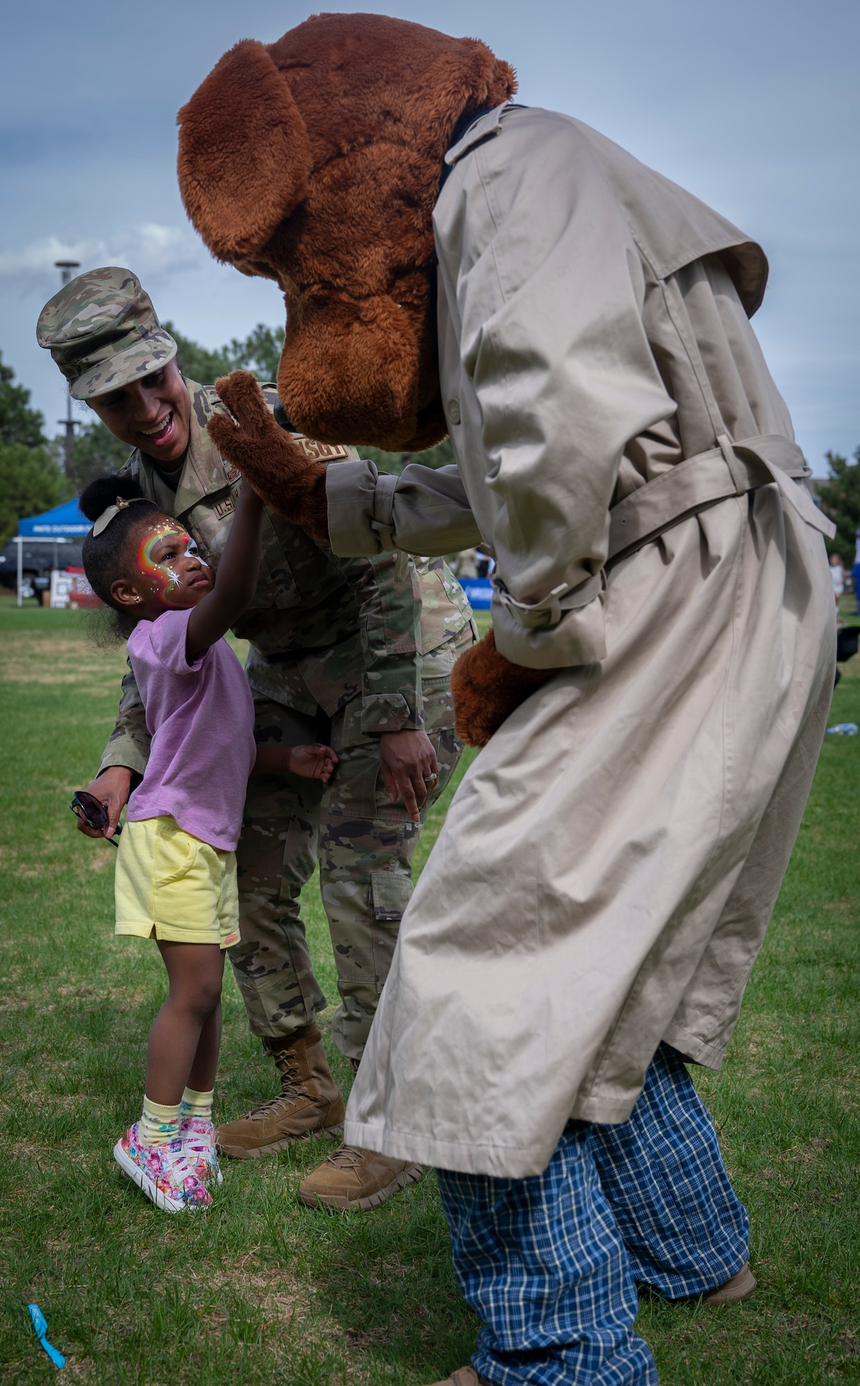 Calee, 3, high-fives McRuff the Crime Dog, as her mother, U.S. Air Force Senior Master Sgt. Michelle Shipp, 21st Security Force Squadron first sergeant, cheers her on at the Defender’s Fair at Peterson Space Force Base, Colorado, May 19, 2022. The event had live music, games, educational displays and food trucks for all to enjoy. (U.S. Space Force photo by Senior Airman Jonathan Whitely)
