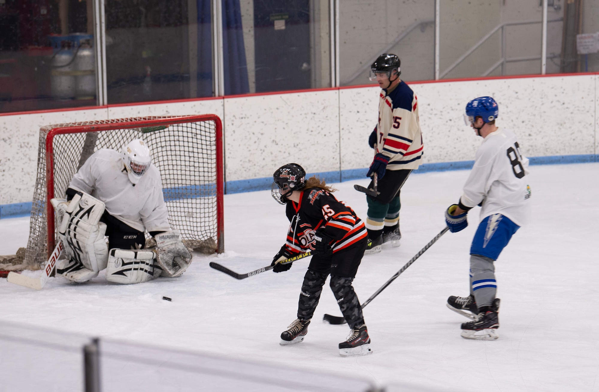 Female hockey player takes a shot at the goal.