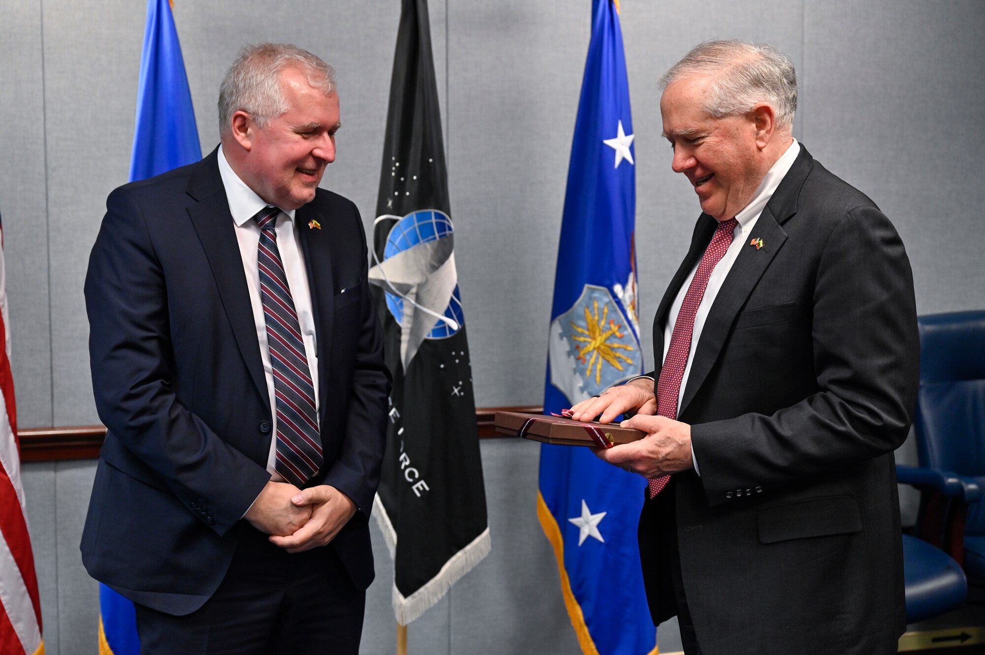 Secretary of the Air Force Frank Kendall, right, and Lithuanian Minister of National Defense Arvydas Anušauskas exchange gifts after a meeting.