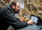 Kevin Vergason, apprentice electrician, Shop 51, Electricians, uses the BILT app on a tablet to build components for a 5-KV circuit breaker. Puget Sound Naval Shipyard & Intermediate Maintenance Facility is piloting this app in the breaker shop with step-by step work instructions to walk mechanics through the assembly and disassembly of two different breakers. (US Navy photo by Wendy Hallmark)