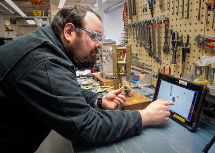 Kevin Vergason, apprentice electrician, Shop 51, Electricians, uses the BILT app on a tablet to build components for a 5-KV circuit breaker. Puget Sound Naval Shipyard & Intermediate Maintenance Facility is piloting this app in the breaker shop with step-by step work instructions to walk mechanics through the assembly and disassembly of two different breakers. (US Navy photo by Wendy Hallmark)