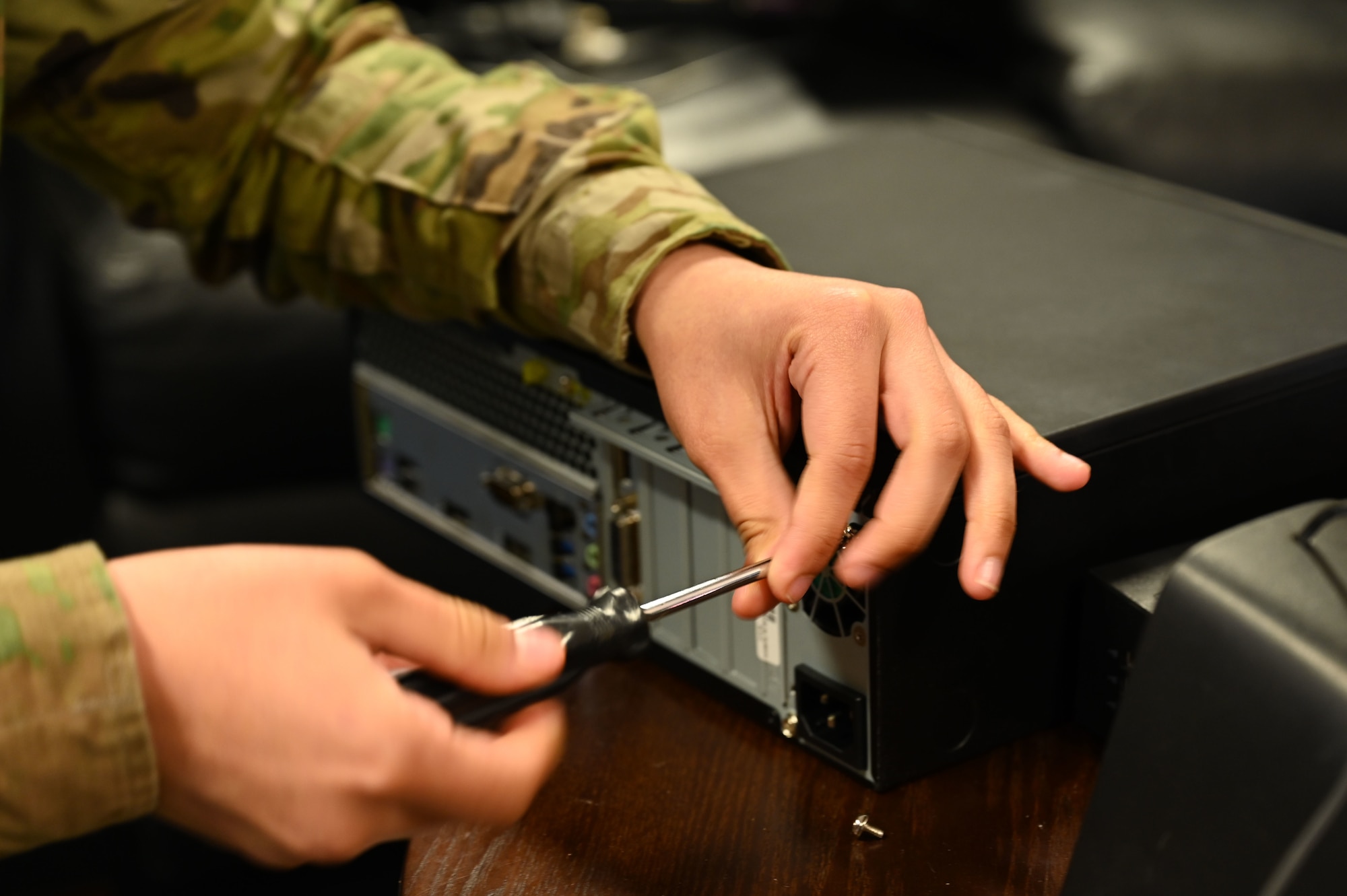 U.S. Air Force Airman 1st Class Arely Juarez Hernandez, client systems operator assigned to the 517th Training Group, opens a desktop computer case at Presidio of Monterey, Calif., May 12, 2022. Juarez Hernandez is trained to work on both hardware and software to support the 517th TRG mission. (U.S. Air Force photo by Master Sgt. Jocelyn A. Ford)