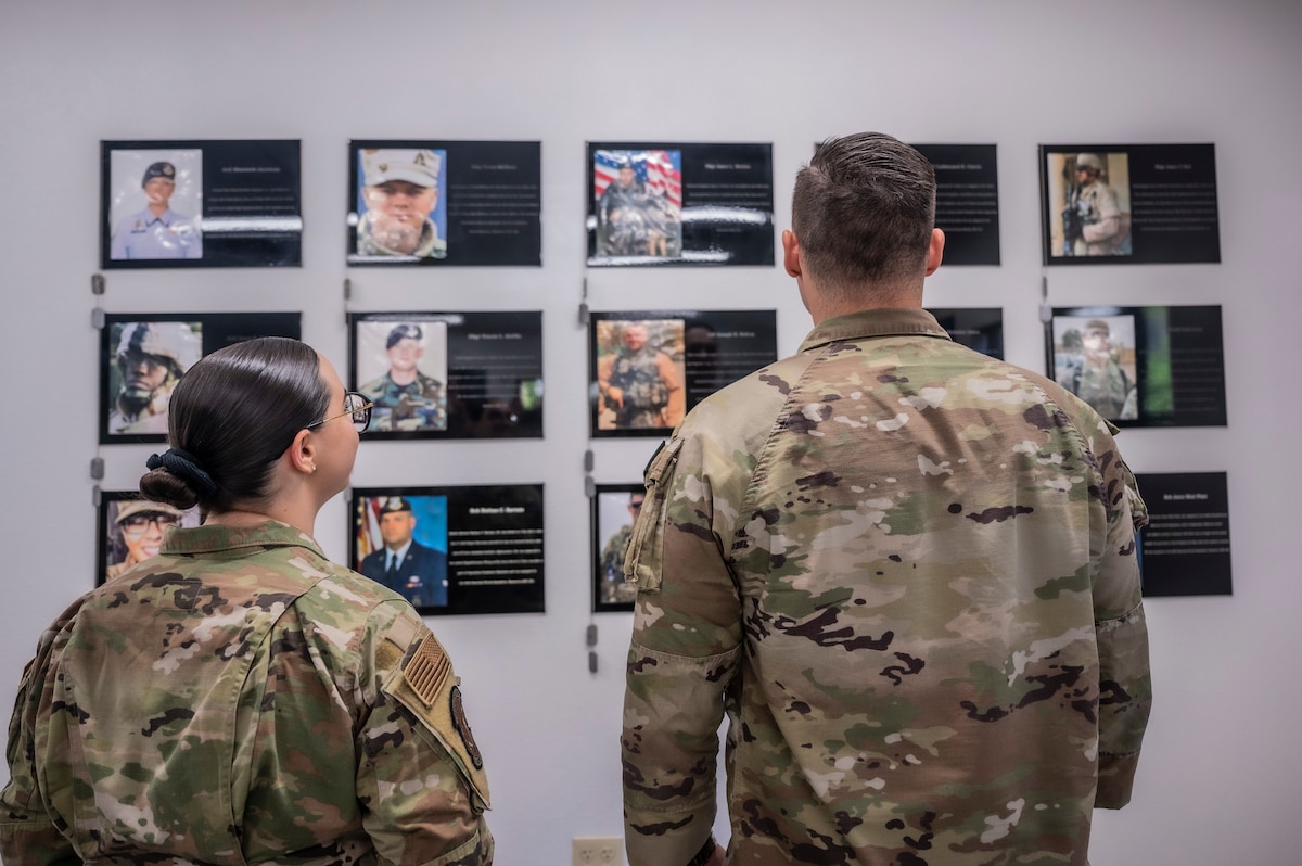 A photo of Airmen looking at a memorial wall.