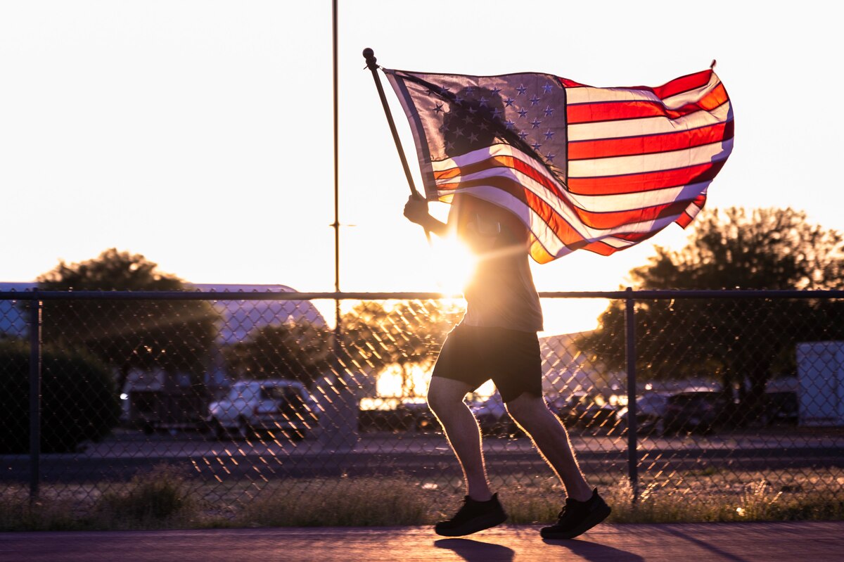 A photo of an Airman running with a flag.