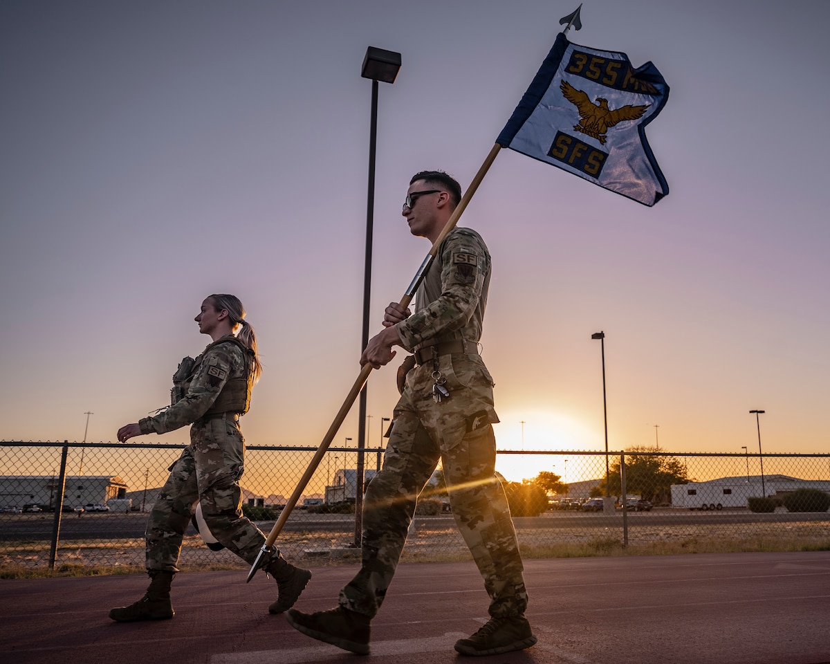 A photo of Airmen carrying a flag.