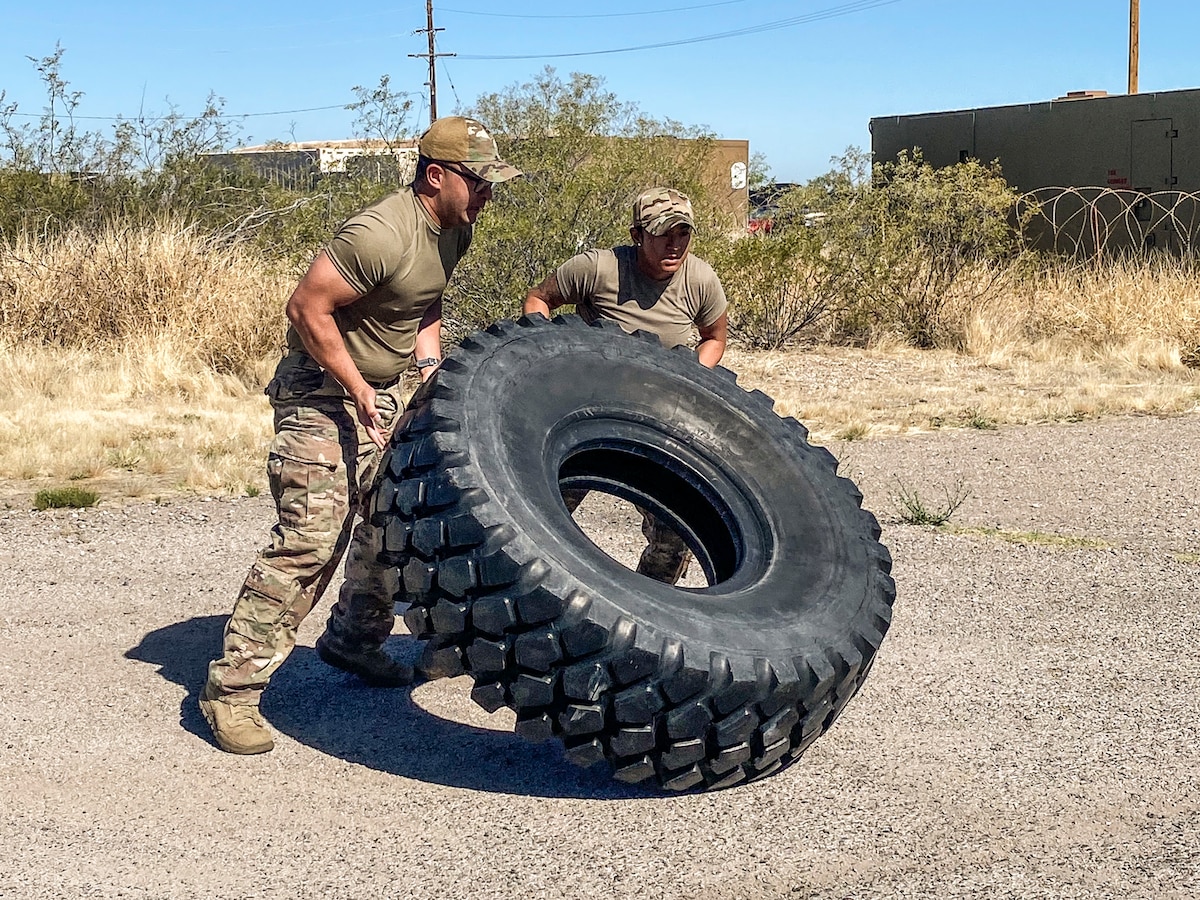 A photo of Airmen pushing a tire.