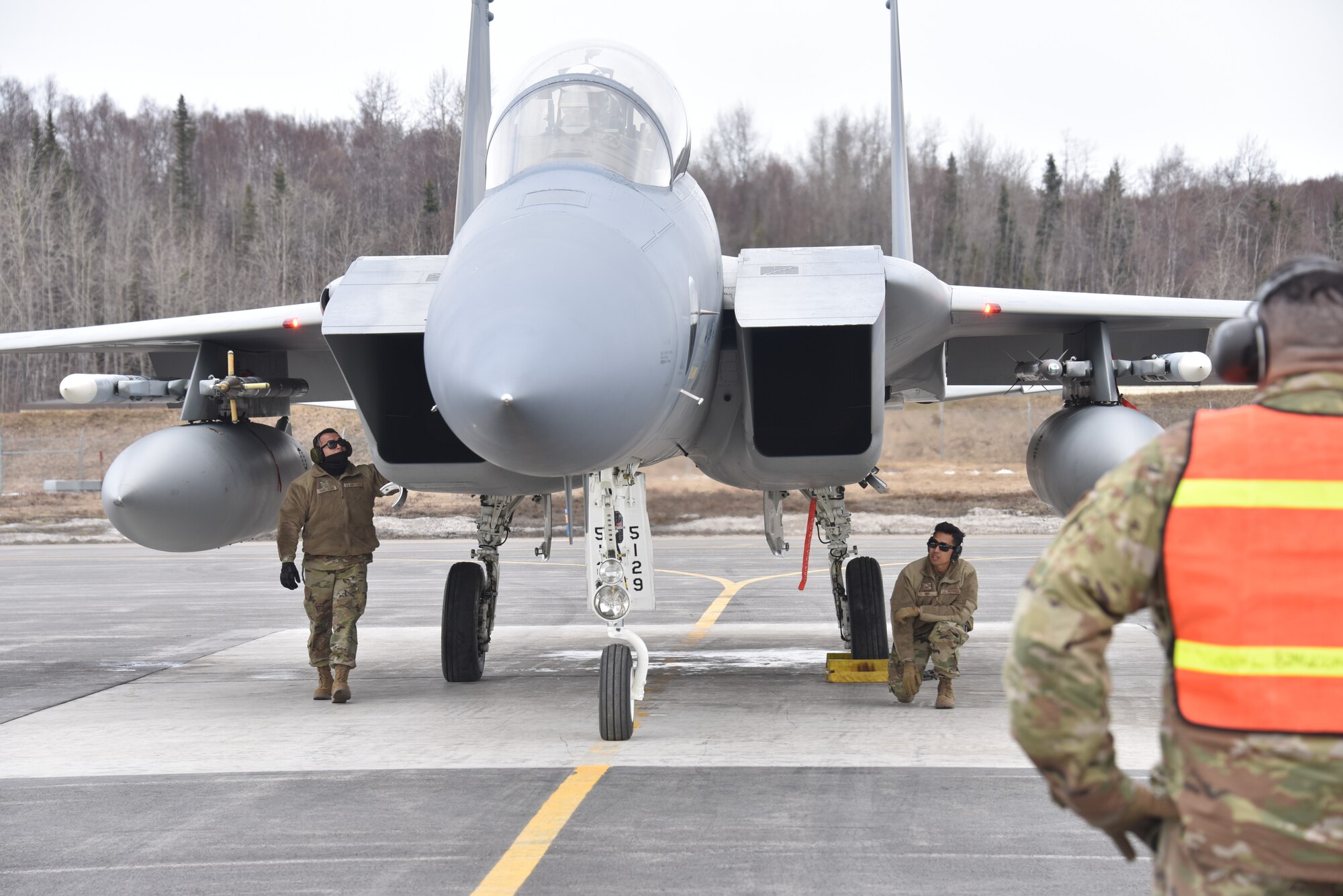 U.S. Air Force Aircraft Armament Systems specialists assigned to the 144th Fighter Wing ready the weapon systems aboard an F-15C Eagle to prepare the aircraft for launch, April 21, 2022, while on a training mission at Joint Base Elmendorf-Richardson, Alaska.