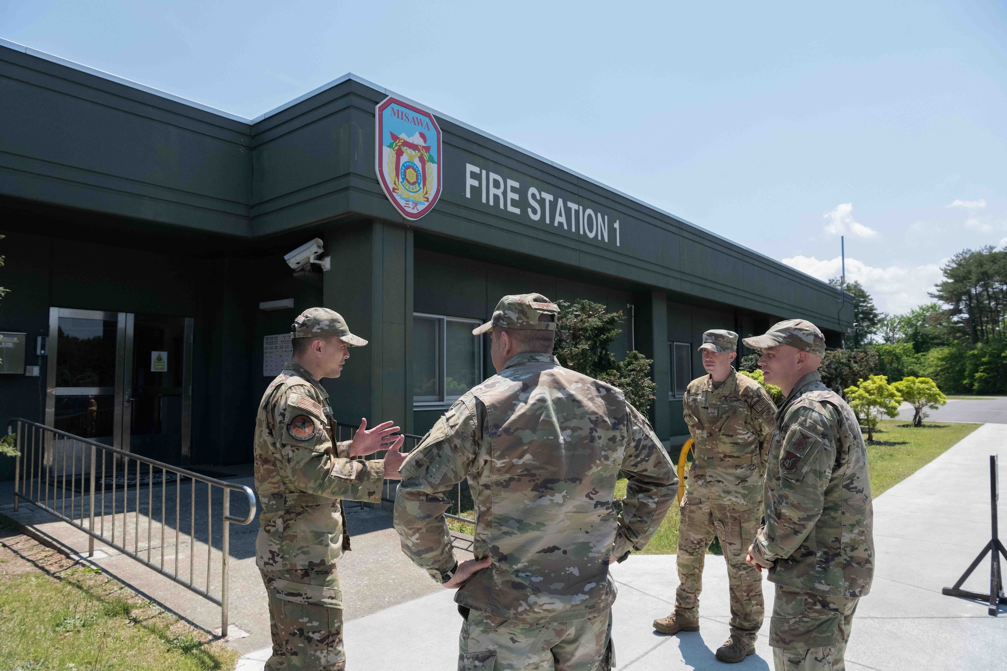 Military members stand in front of the Fire Station.