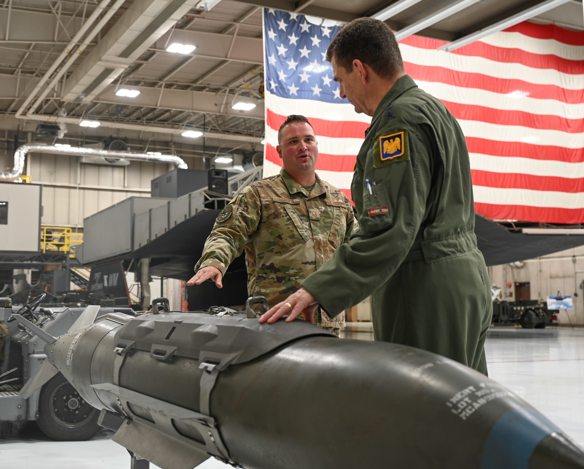 U.S. Air Force Master Sgt. Brock Schuld, 131st Aircraft Maintenance Squadron 131st Bomb Wing, Missouri National Guard, speaks with Lt. Gen. Michael Loh, director, Air National Guard, at the Whiteman Air Force Base, Missouri, Weapons Load Trainer, May 13, 2022. The trainer allows Team Whiteman Airmen to learn all aspects of the munitions enterprise for the B-2 Spirit bomber in a safe and controlled environment. (U.S. Air Force photo by Airman 1st Class Bryson Britt)