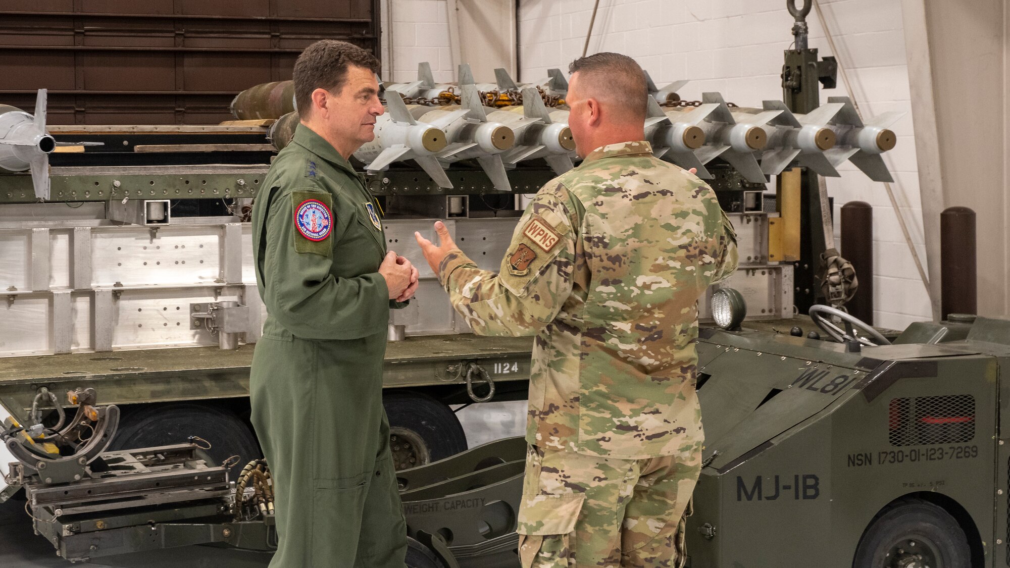 U.S. Air Force Master Sgt. Brock Schuld, 131st Aircraft Maintenance Squadron, 131st Bomb Wing, Missouri National Guard, discusses the Weapons Load Trainer at Whiteman Air Force Base, Missouri, with Lt. Gen. Michael Loh, director, Air National Guard, May 13, 2022. The trainer allows Team Whiteman Airmen to learn all aspects of the munitions enterprise for the B-2 Spirit bomber in a safe and controlled environment. (U.S. Air National Guard photo by Master Sgt. John E. Hillier)
