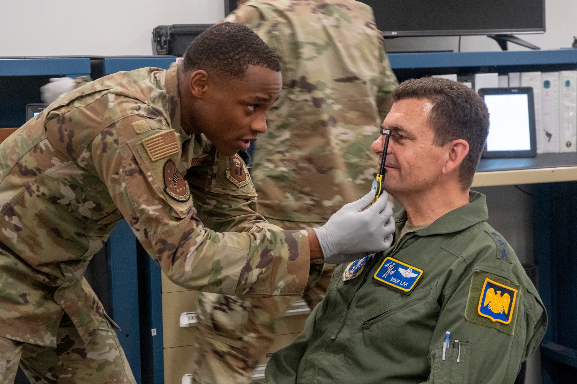 U.S. Air Force Senior Airman Anthony Ratliff, aircrew flight equipment technician with 509th Operations Support Squadron, measures Air National Guard Director Lt. Gen. Michael Loh for a helmet during his visit to Whiteman Air Force Base, Missouri, May 13, 2022. Loh visited the Missouri Air National Guard's 131st Bomb Wing to learn about the total force B-2 Spirit stealth bomber mission. (U.S. Air National Guard photo by Master Sgt. John E. Hillier)