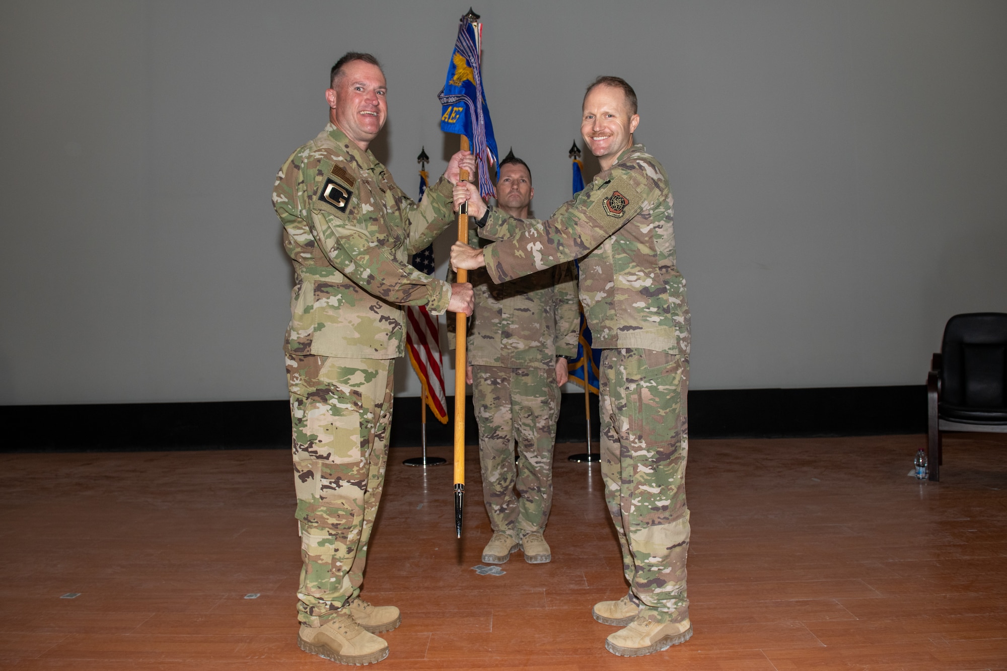 U.S. Air Force Col. Rob Lowe passes a guidon to Maj. Gen. Kenneth Bibb during an inactivation ceremony for the 385th Air Expeditionary Group on Al Udeid Air Base, Qatar, May 1, 2022. The 385th AEG is responsible for the airlift of over 120,000 vulnerable Afghans from Afghanistan.
