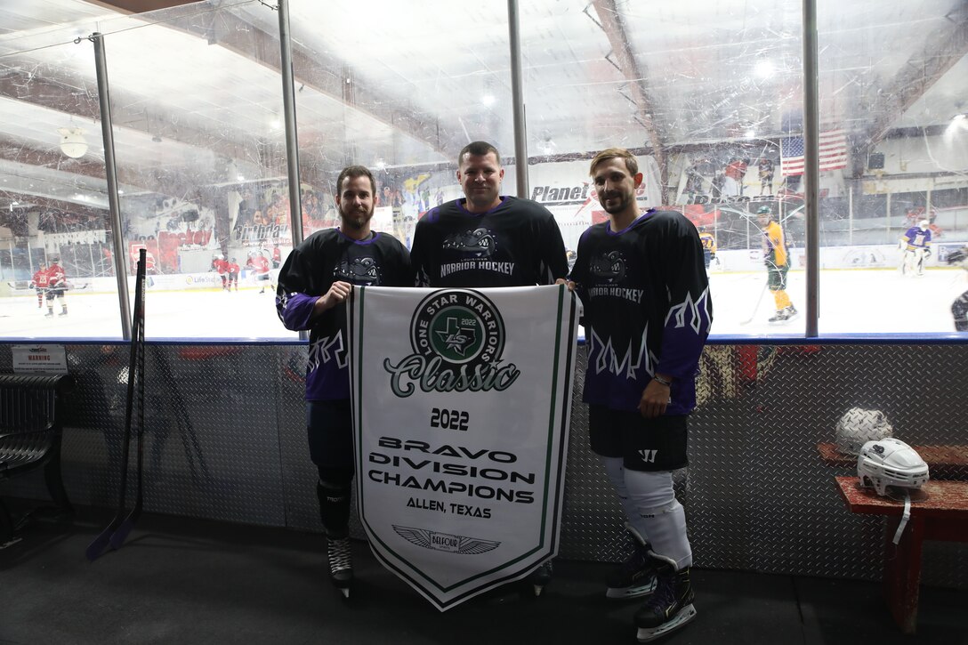 U.S. Marine Corps Master Gunnery Sgt. Kevin Boggs, the Recruiting Station Baton Rouge Recruiter Instructor, center, and his teammates, Tyler Guilbeau, left, and Tyler Brown, right, pose for a photo before their hockey match at Planet Ice Rink in Lafayette, Louisiana, April 24, 2022. Boggs is the founder of the Louisiana Warriors, a veterans hockey team based out of Lafayette, Louisiana. The Louisiana Warriors' purpose is to provide veterans the opportunity to foster camaraderie, build a local support system, and continue fueling the spirit of competition. (U.S. Marine Corps photo by Sgt. Danielle R. Prentice)