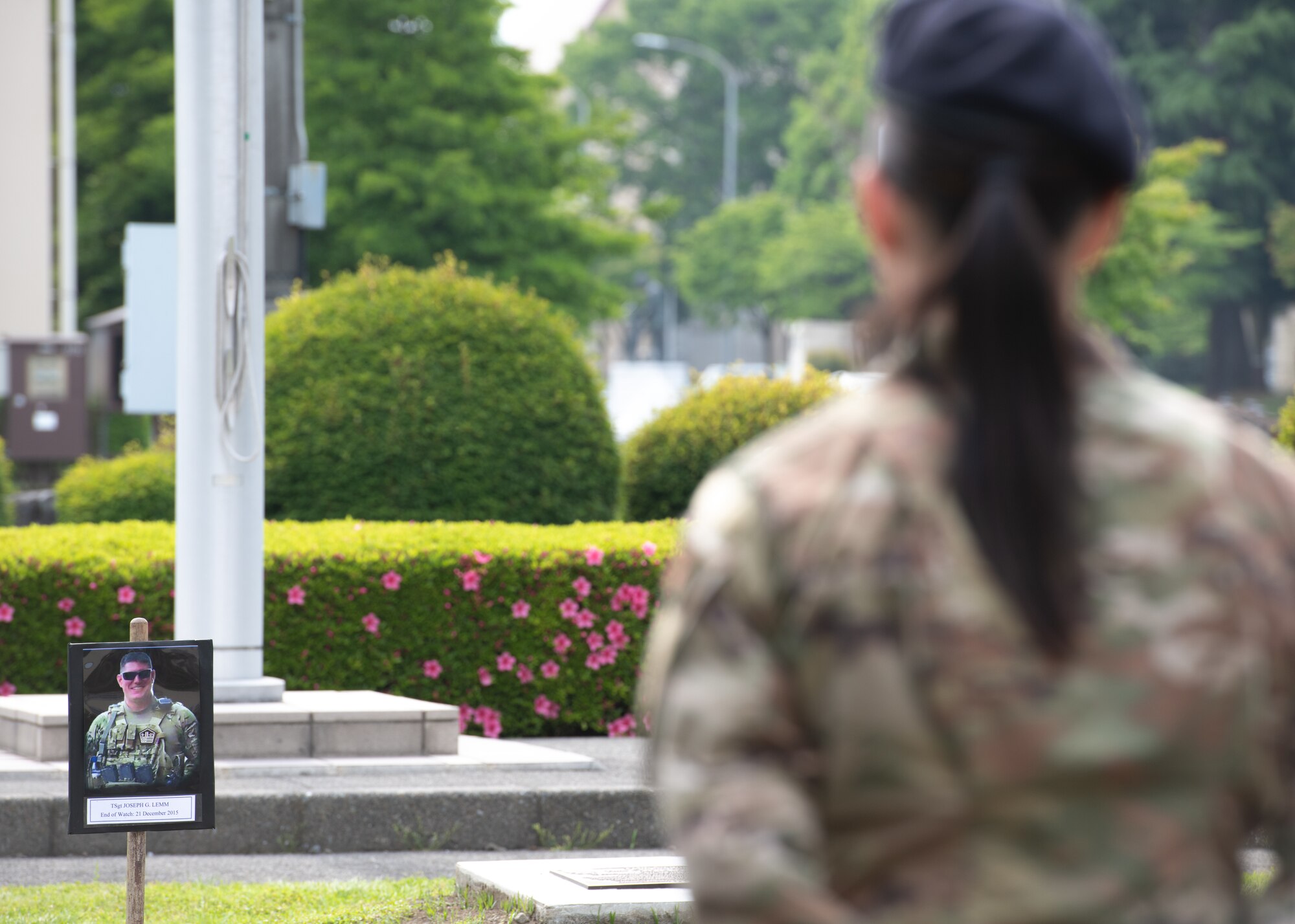 An Airman from the 374th Security Forces Squadron listens to a speech during a police retreat ceremony at Yokota Air Base, Japan, May 20, 2022. The speaker listed the names of SFS and Airmen who have lost their lives in the line of duty. (U.S. Air Force photo by Machiko Arita)