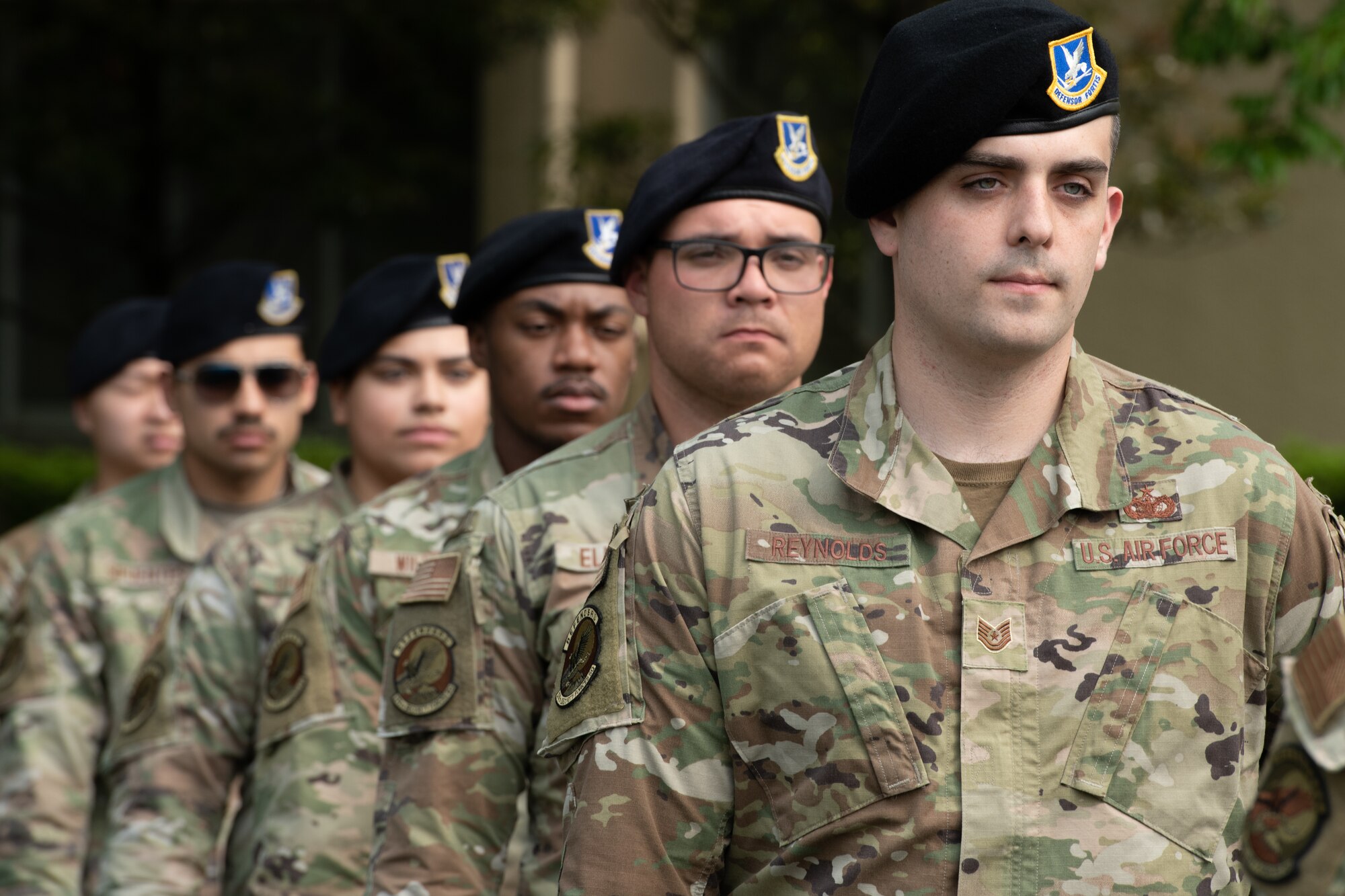 Airmen from the 374th Security Forces Squadron stand in formation before firing a salute during a police retreat ceremony at Yokota Air Base, Japan, May 20, 2022. The 374th SFS held the ceremony during Police Week to honor law enforcement personnel as well as recognize the dangers and risks they face every day. (U.S. Air Force photo by Machiko Arita)