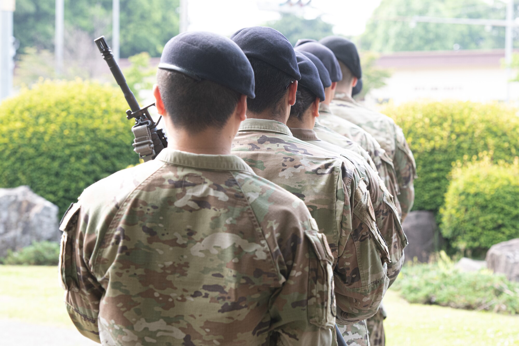 Airmen from the 374th Security Forces Squadron walk away after firing a salute during a police retreat ceremony at Yokota Air Base, Japan, May 20, 2022. The 374th SFS held the ceremony during Police Week to honor law enforcement personnel as well as recognize the dangers and risks they face every day. (U.S. Air Force photo by Machiko Arita)