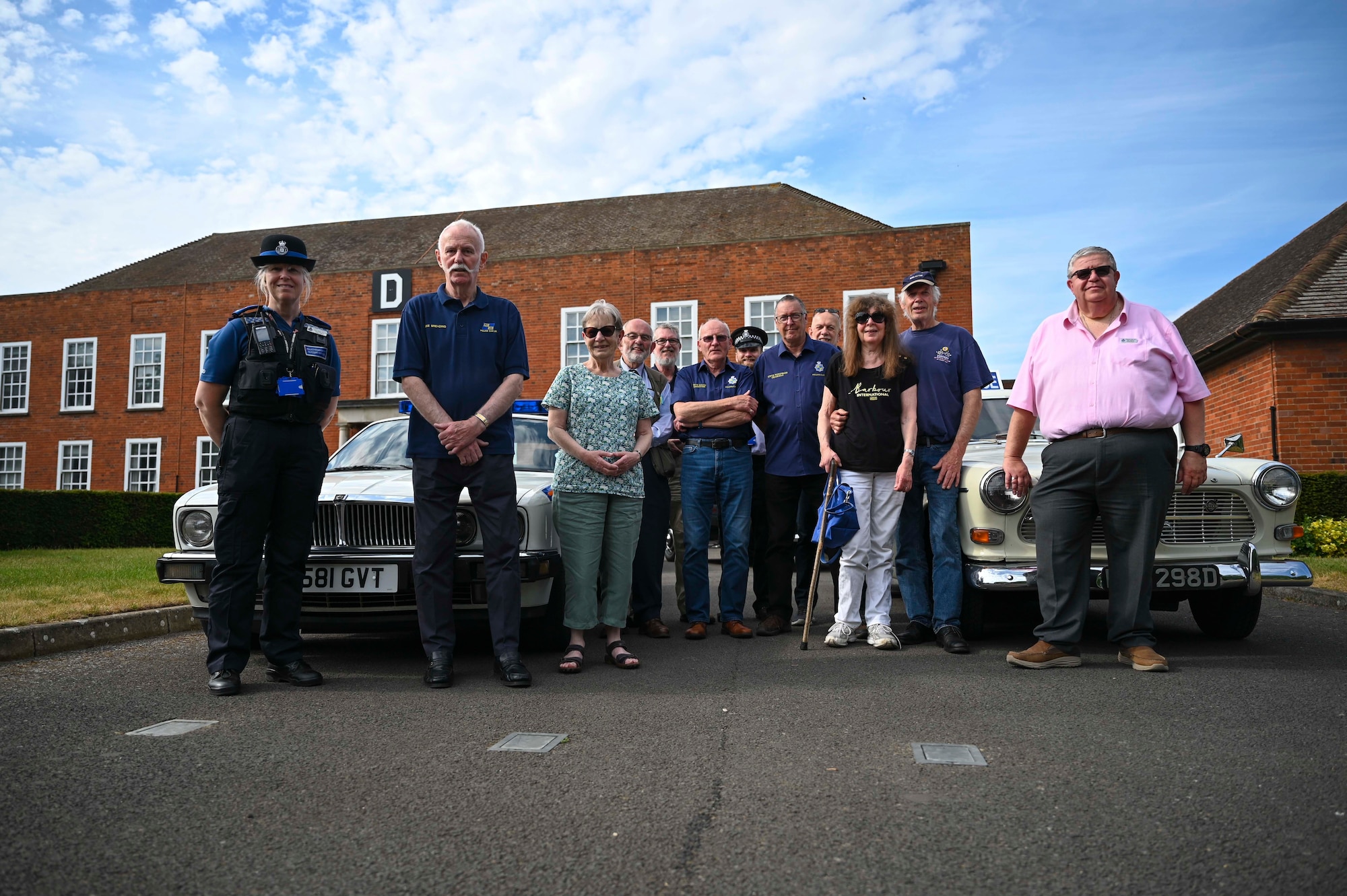 Members of Police Car United Kingdom stand for a group photo in front of retired and active police vehicles at Royal Air Force Mildenhall, England, May 17th, 2022.