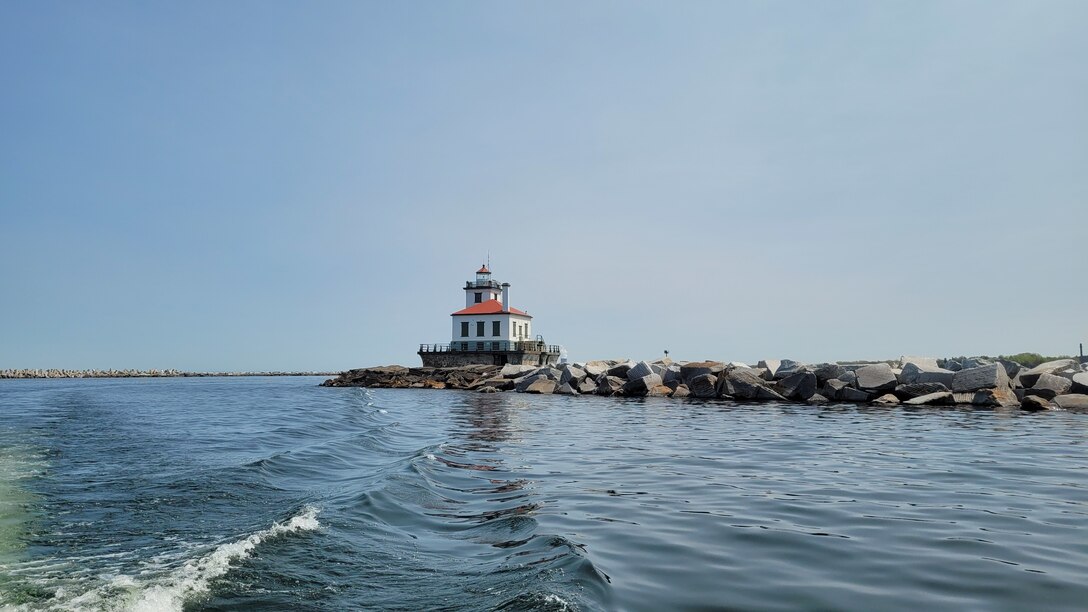 Lighthouse at the end of a stone breakwater.