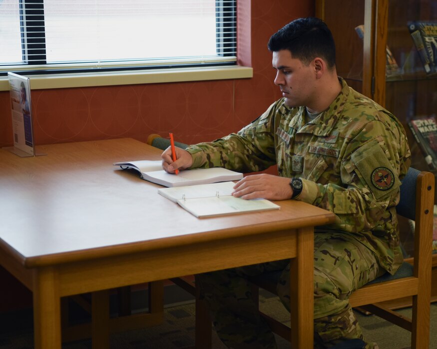 U.S. Air Force Staff Sgt. Ramon Ramirez-Mendez, 316th Training Squadron instructor, takes notes at the Consolidated Learning Center, Goodfellow Air Force Base, Texas, May 23, 2022. Ramirez-Mendez selected a general psychology class to understand ways to engage his students and improve their learning. (U.S. Air Force photo by Senior Airman Ethan Sherwood)