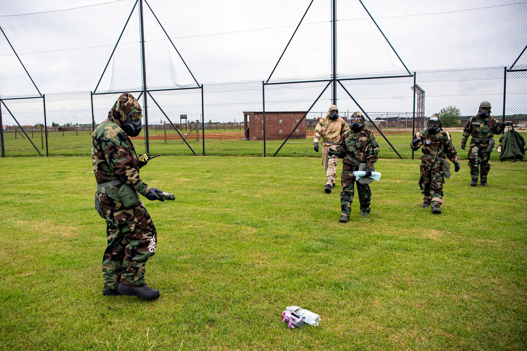 An Airman from the 423d Civil Engineer Squadron, identifies a simulated contaminated area during an exercise at RAF Alconbury, England, May 19, 2022. The exercise was geared towards training Airmen on how to properly control and examine a contaminated area after a simulated chemical attack while in Mission Oriented Protective Posture Gear. (U.S. Air Force photo by Staff Sgt. Eugene Oliver)