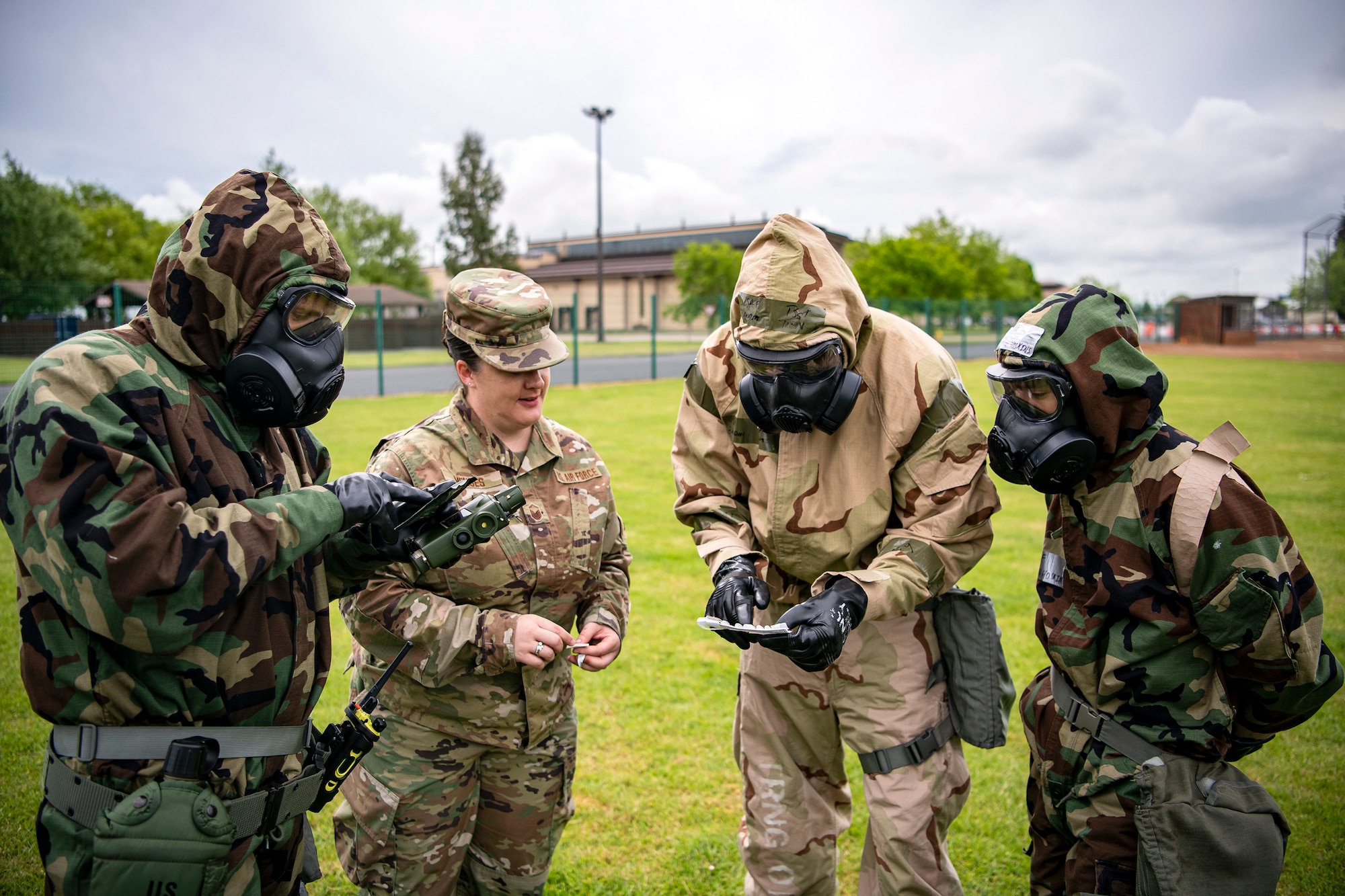 Airmen from the 423d Civil Engineer Squadron examine a M256 kit during an exercise at RAF Alconbury, England, May 19, 2022. The exercise was geared towards training Airmen on how to properly control and examine a contaminated area after a simulated chemical attack while in Mission Oriented Protective Posture Gear. (U.S. Air Force photo by Staff Sgt. Eugene Oliver)