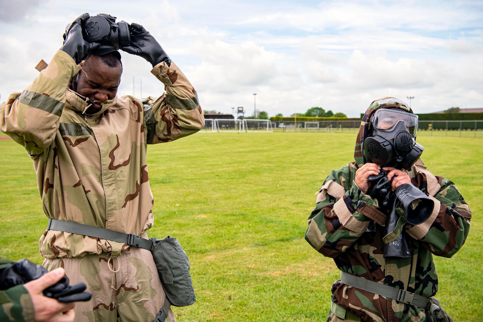 Airmen from the 423d Civil Engineer Squadron, take off their Mission Oriented Protective Posture gear following an exercise at RAF Alconbury, England, May 19, 2022. The exercise was geared towards training Airmen on how to properly control and examine a contaminated area after a simulated chemical attack while in Mission Oriented Protective Posture Gear. (U.S. Air Force photo by Staff Sgt. Eugene Oliver)