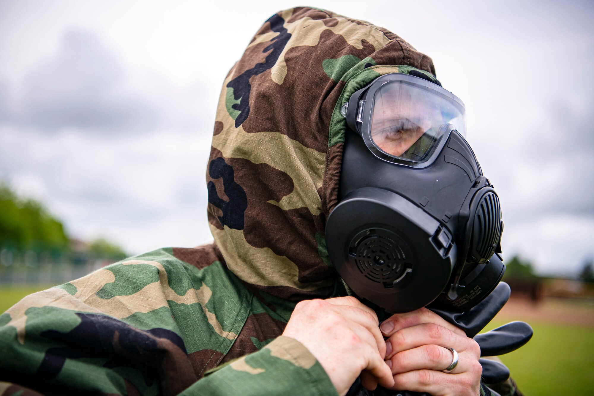 An Airman from the 423d Civil Engineer Squadron, prepares to take off his Mission Oriented Protective Posture gear following an exercise at RAF Alconbury, England, May 19, 2022. The exercise was geared towards training Airmen on how to properly control and examine a contaminated area after a simulated chemical attack while in Mission Oriented Protective Posture Gear. (U.S. Air Force photo by Staff Sgt. Eugene Oliver)