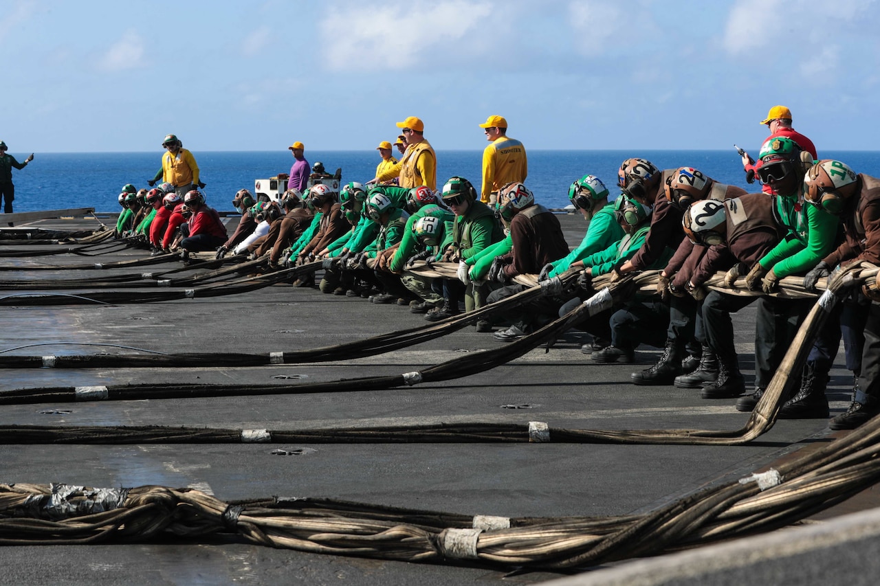 Sailors set up a barricade on the deck of a ship.
