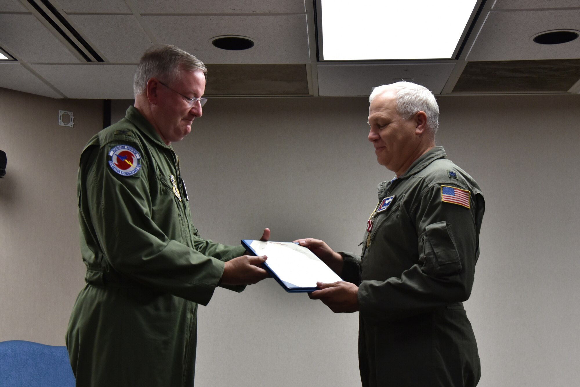 Col. Jeff Van Dootingh on the left hands Lt. Col. Dwayne Russell on the right his Meritorious Service Medal certificate during his retirement ceremony.