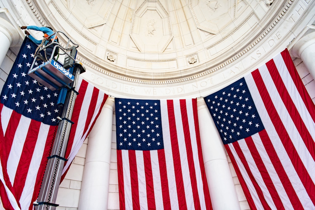 A man hangs an American flag at Arlington National Cemetery.